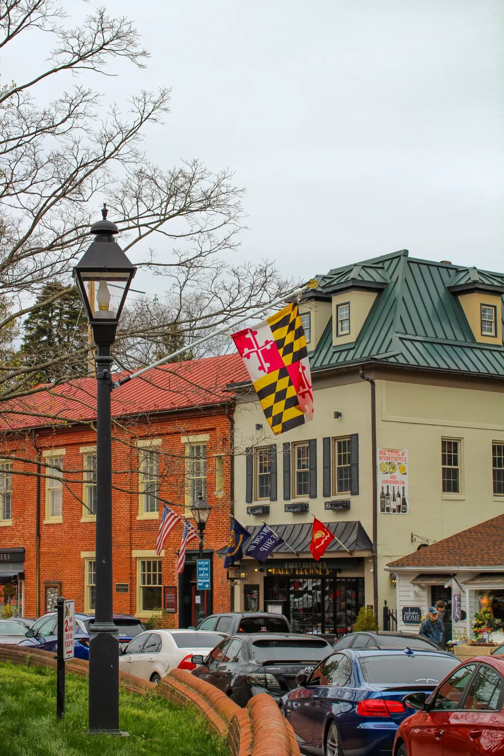 Maryland and American flags among the brick storefronts of downtown Annapolis