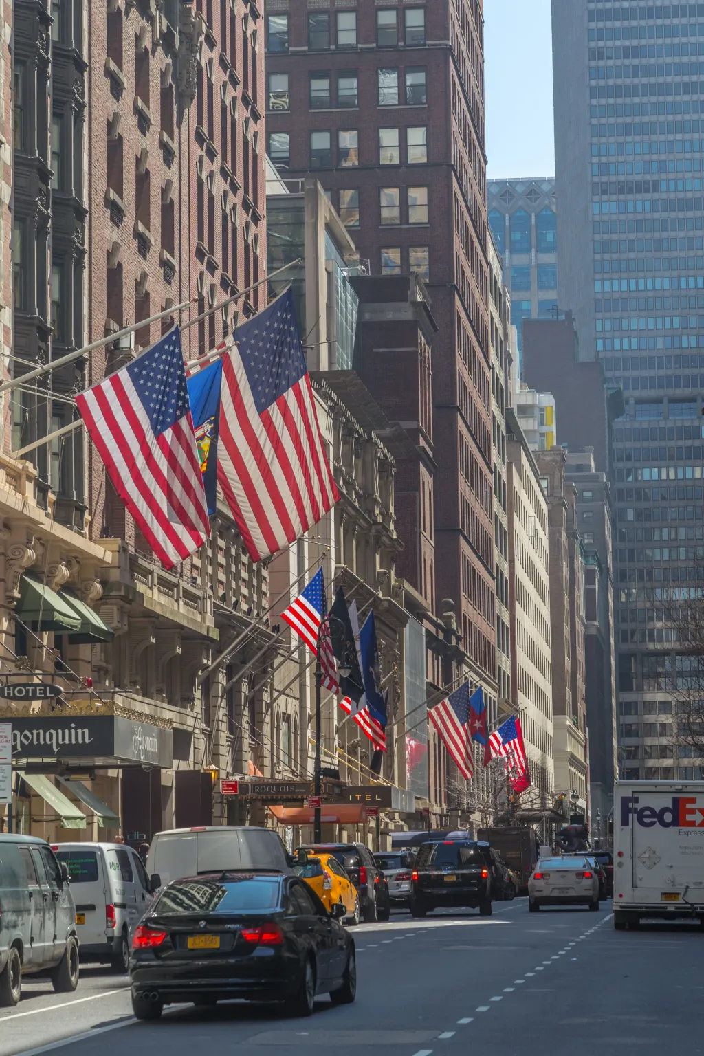American flags above a New York City street lined with tall buildings